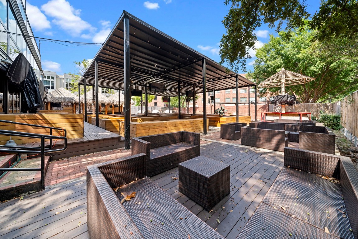 1916 Baldwin Street Houston, TX 77019 - Photo 16 of 37 a view of a patio with couches table and chairs under an umbrella with wooden floor