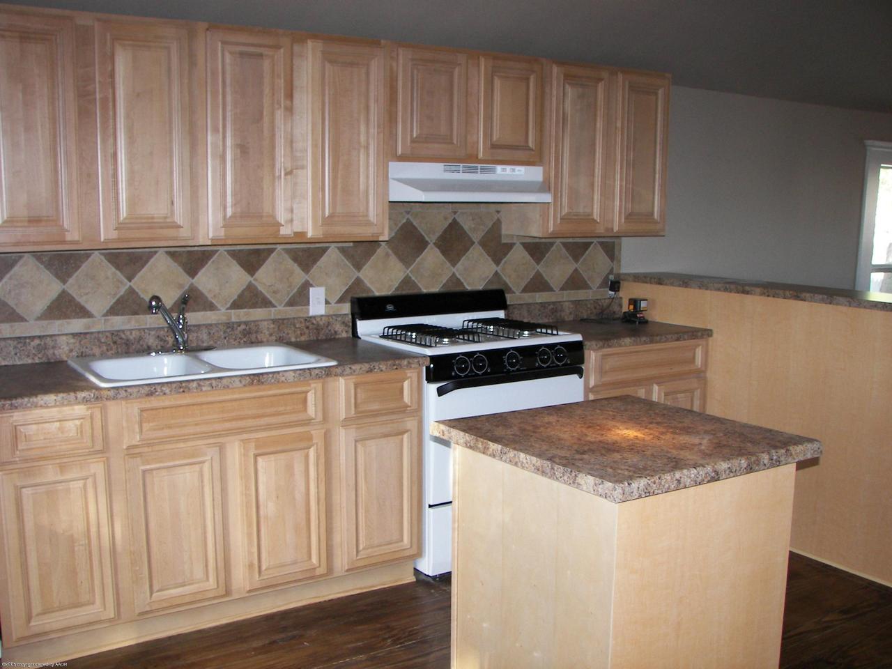 2002 8th Avenue Canyon, TX 79015 - Photo 2 of 6 a kitchen with granite countertop white cabinets and sink