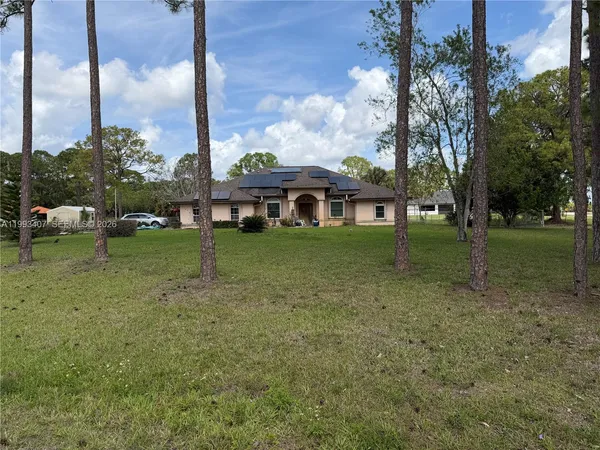 a view of a house with a yard and sitting area