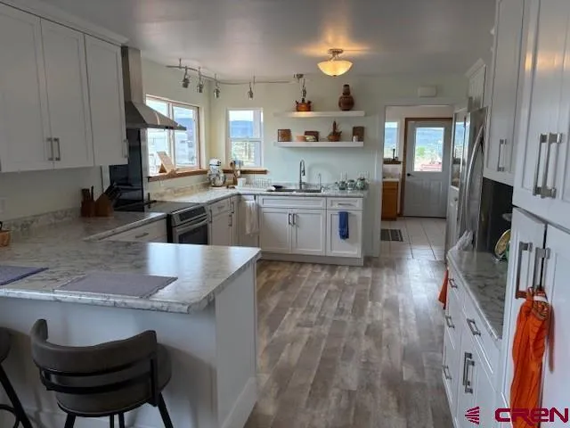 a large kitchen with cabinets wooden floor and stainless steel appliances