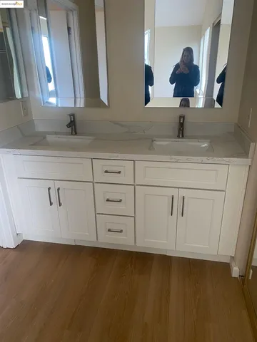 a bathroom with a sink vanity granite and a mirror