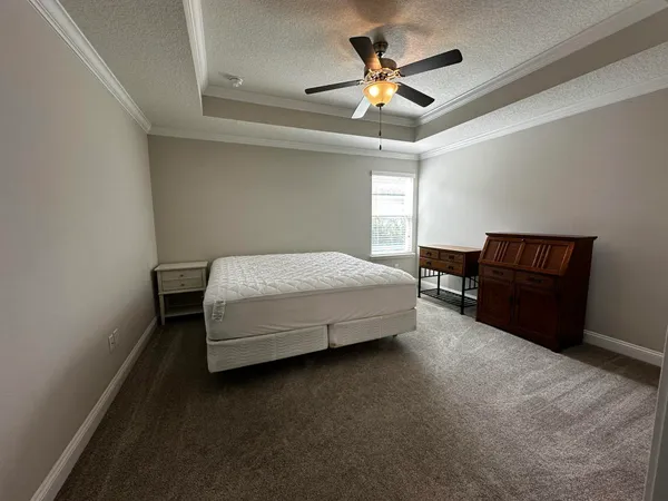 a spacious bedroom with a bed and a ceiling fan