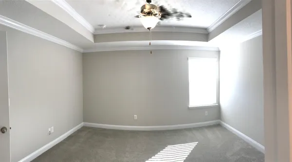 an empty room with a window and chandelier