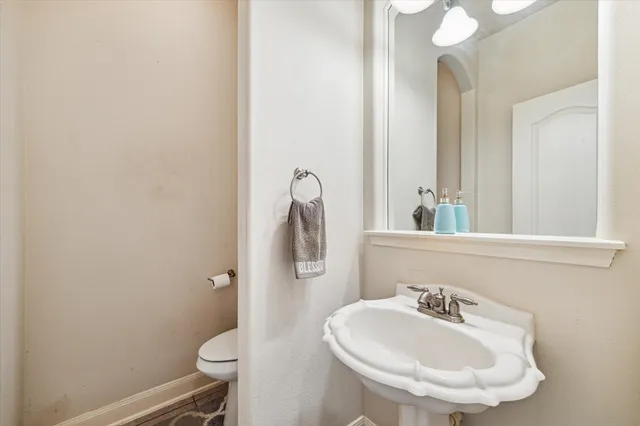a bathroom with a sink toilet and mirror