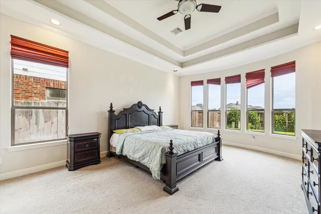 a bed sitting in a spacious bedroom next to a window