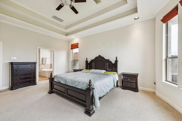a spacious bedroom with a bed and a chandelier