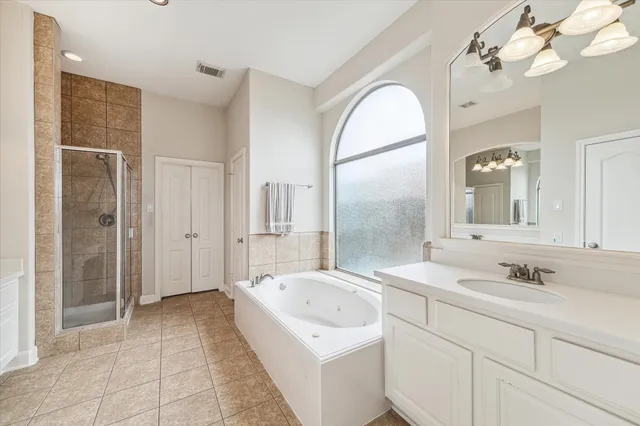 a spacious bathroom with a sink a mirror and a shower