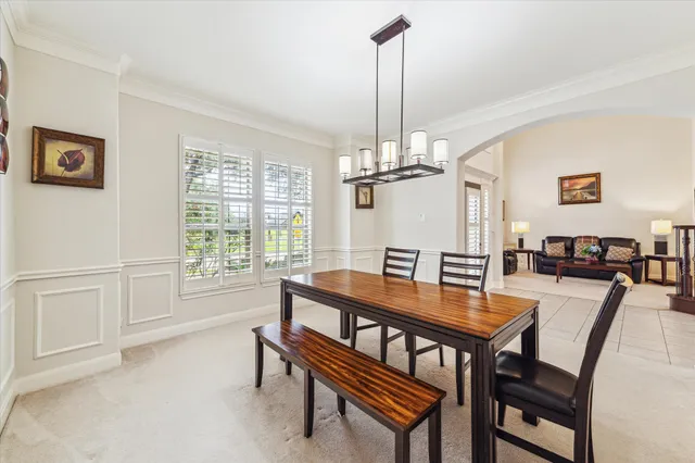 a view of a dining room and livingroom with furniture wooden floor a chandelier