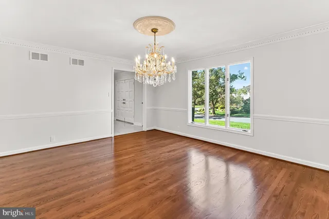 a kitchen with stainless steel appliances granite countertop a refrigerator a stove top oven a large window with wooden floor