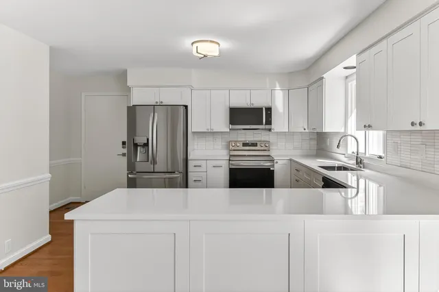 a view of an empty room with wooden floor and closet