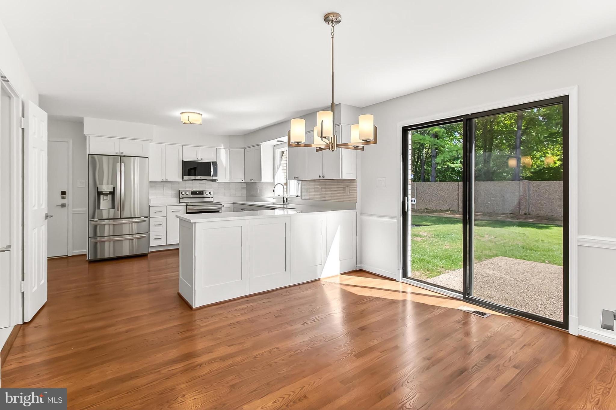 6294 Dunaway Court McLean, VA 22101 - Photo 22 of 76 a kitchen with stainless steel appliances granite countertop a refrigerator a stove top oven a large window with wooden floor
