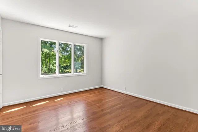 an empty room with windows and fireplace