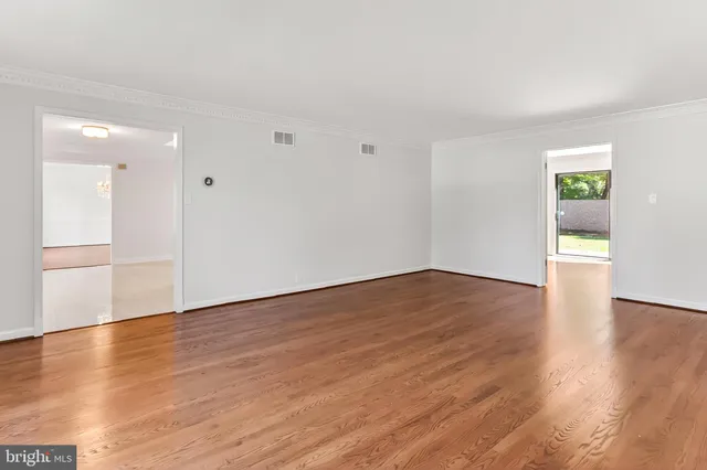 a view of a room with wooden floor chandelier and a window