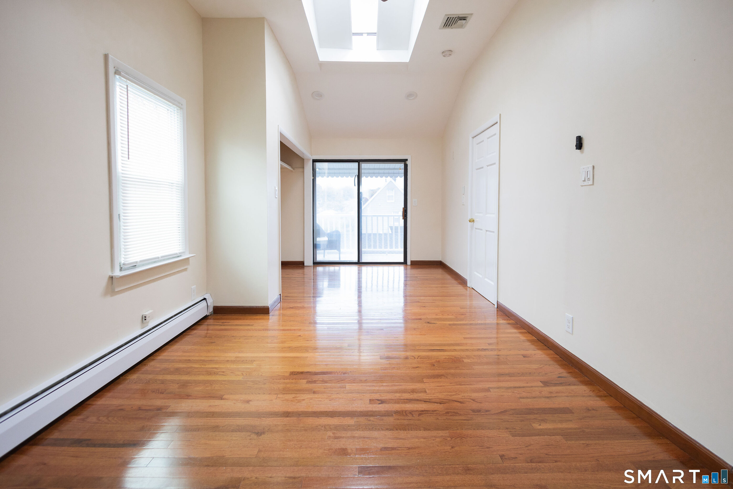 138 Infield Street Bridgeport, CT 06606 - Photo 12 of 34 a view of an empty room with wooden floor and a window