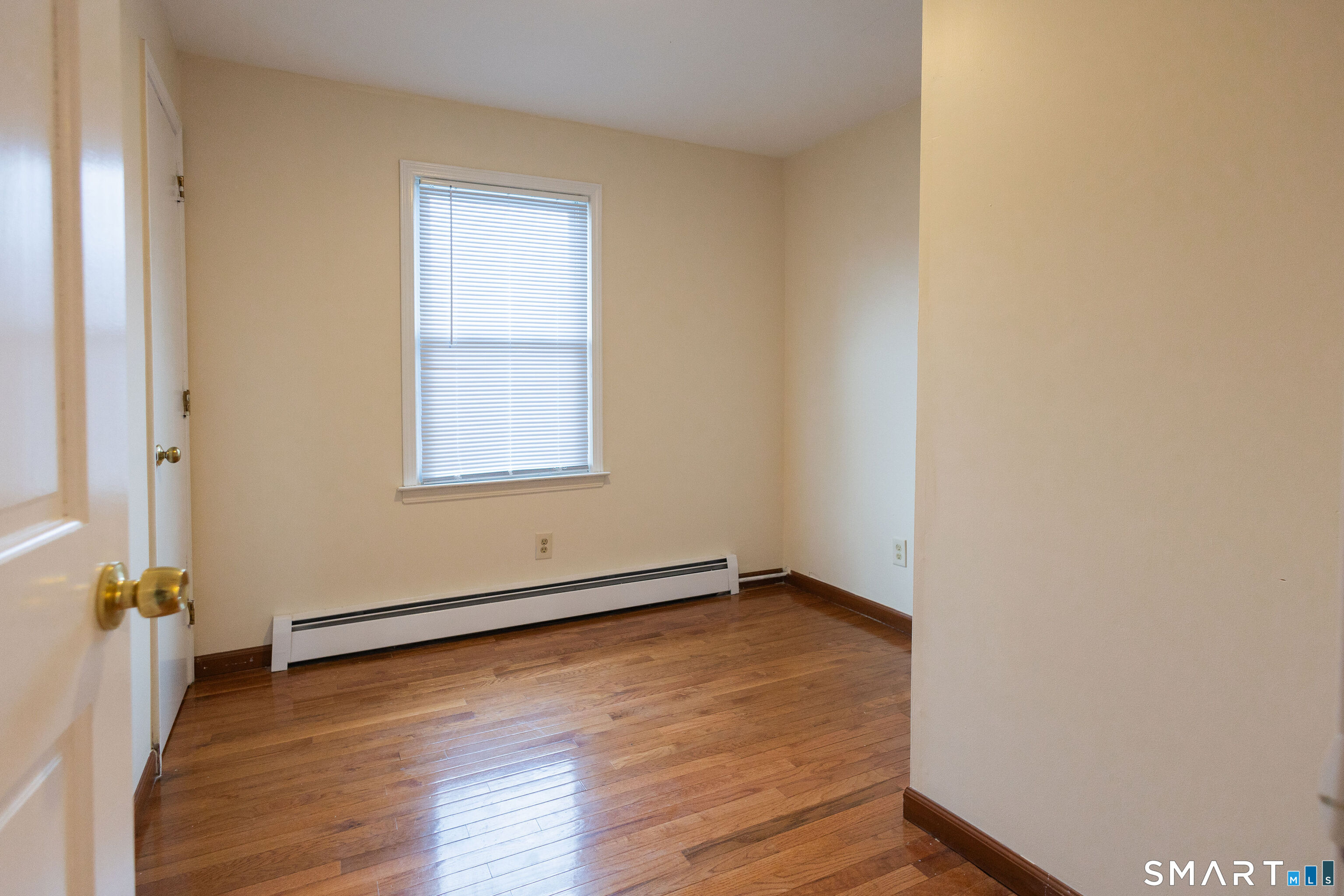 138 Infield Street Bridgeport, CT 06606 - Photo 17 of 34 an empty room with wooden floor and windows