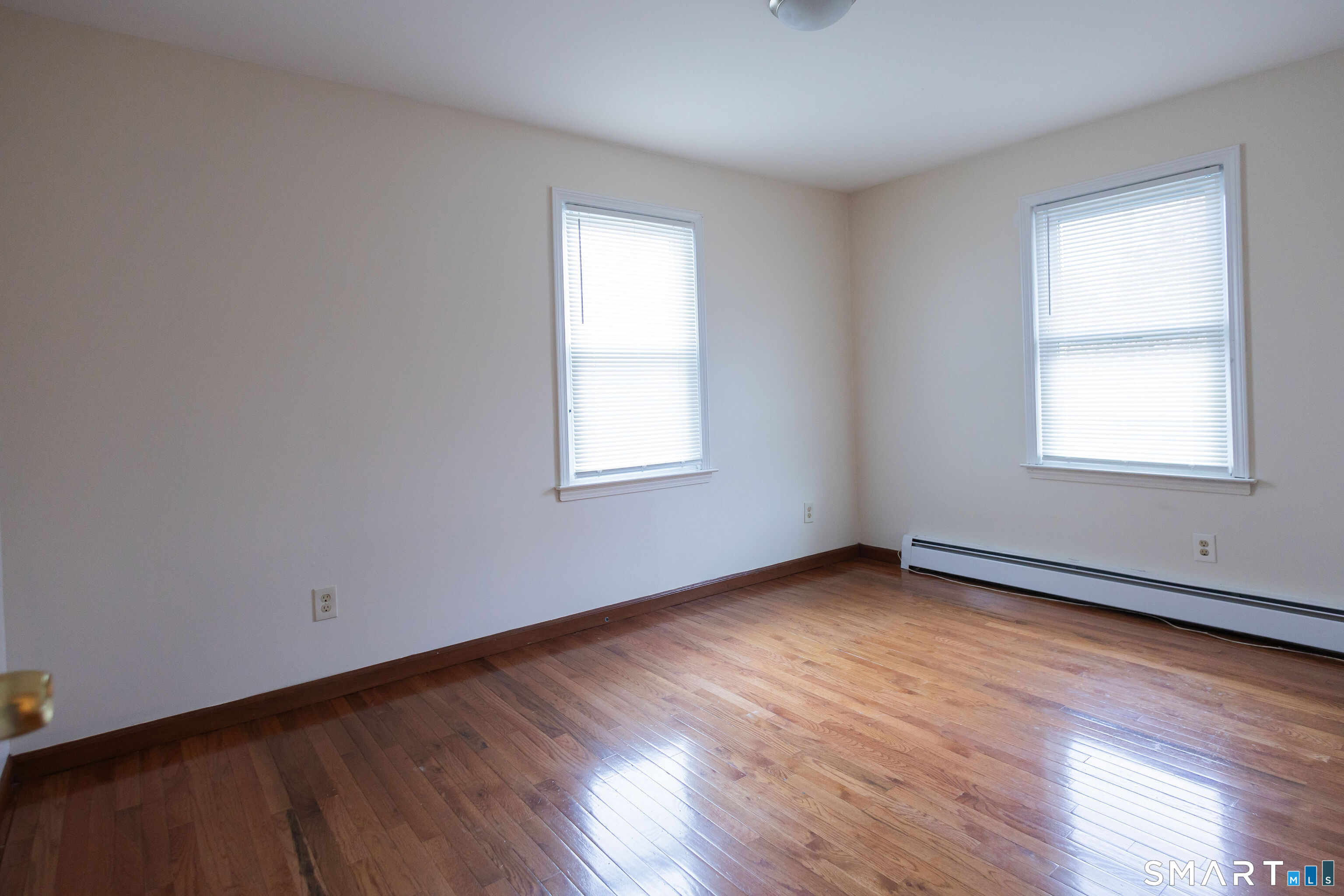 138 Infield Street Bridgeport, CT 06606 - Photo 19 of 34 an empty room with wooden floor and windows