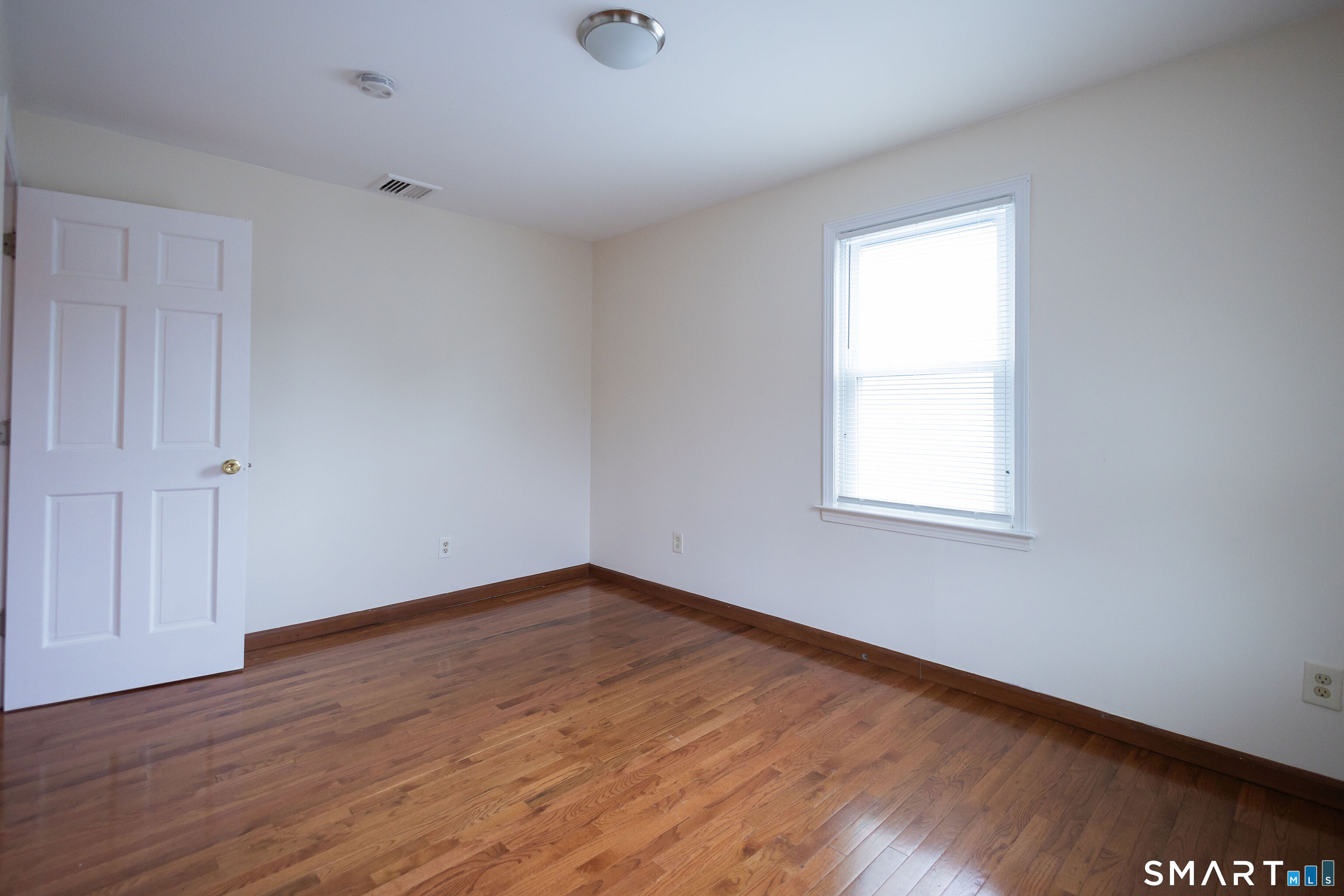 138 Infield Street Bridgeport, CT 06606 - Photo 21 of 34 an empty room with wooden floor and windows
