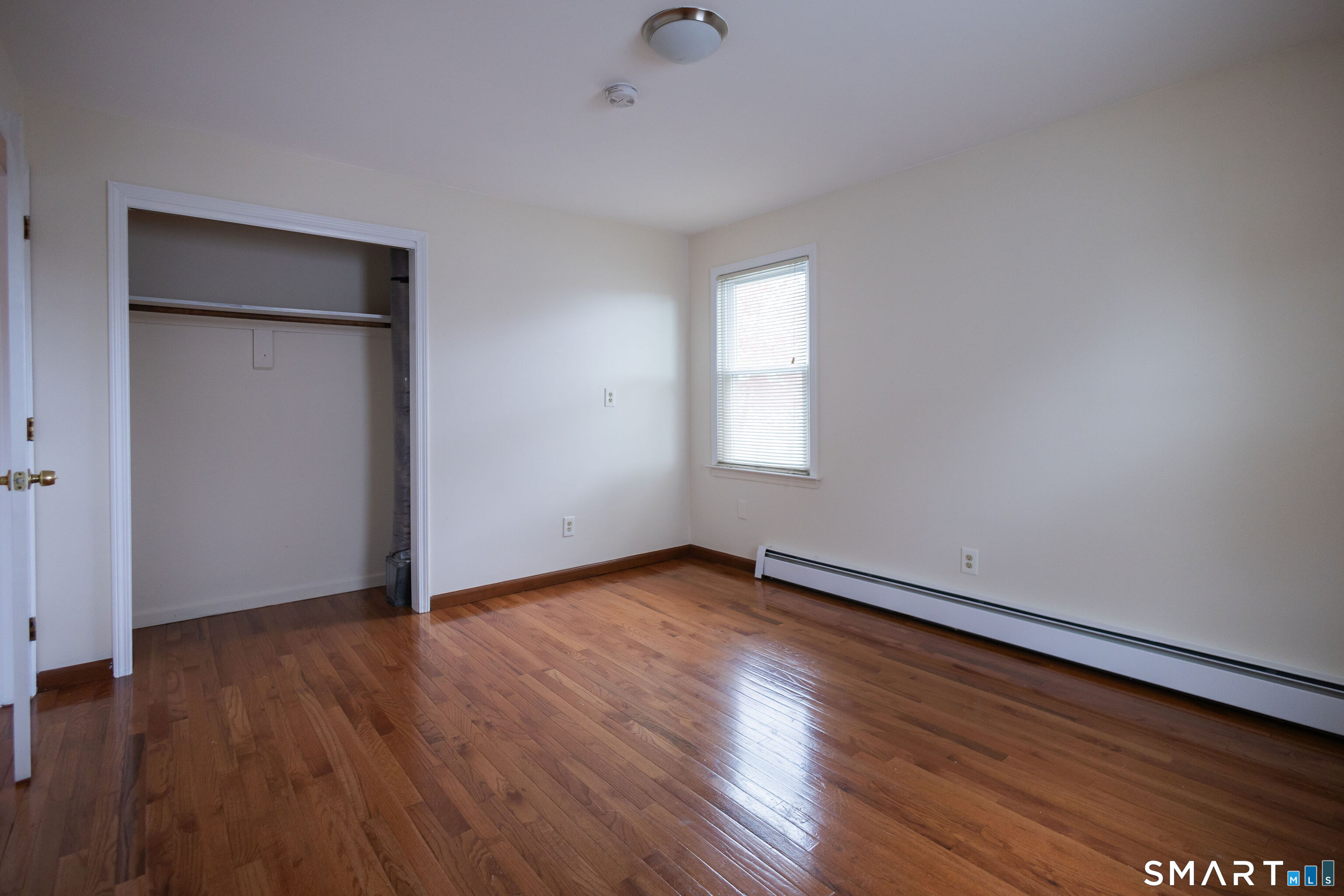 138 Infield Street Bridgeport, CT 06606 - Photo 23 of 34 a view of an empty room with wooden floor and a window