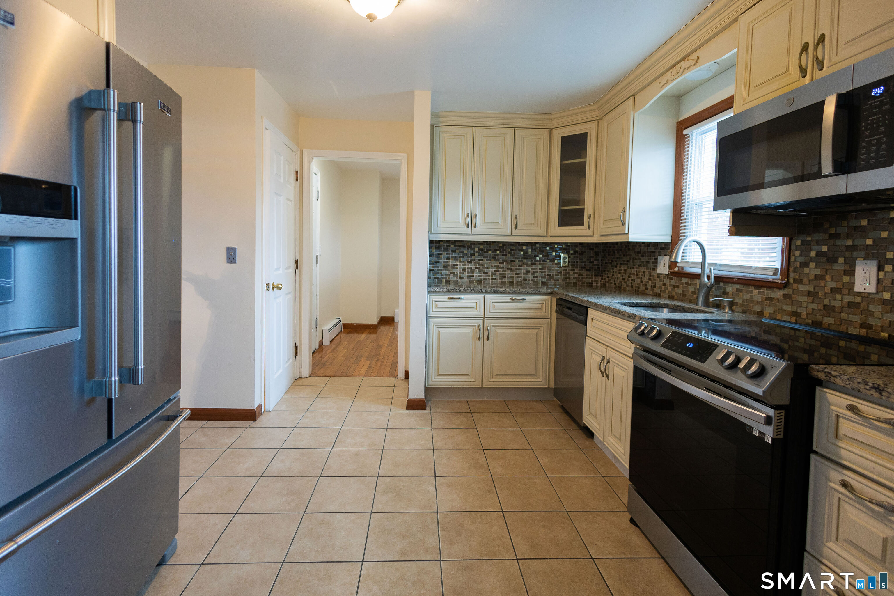 138 Infield Street Bridgeport, CT 06606 - Photo 4 of 34 a kitchen with a stove a sink and a refrigerator
