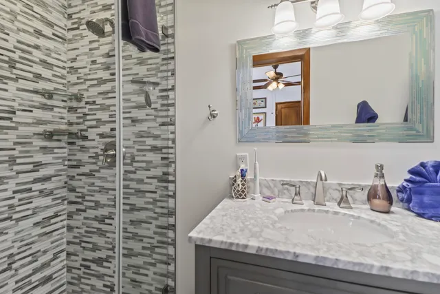 a bedroom with a bed a chandelier and flat screen tv