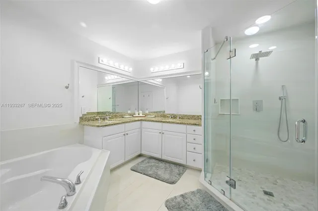 a bathroom with a tub sink shower and mirror