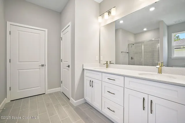 a bathroom with a double vanity sink and a mirror