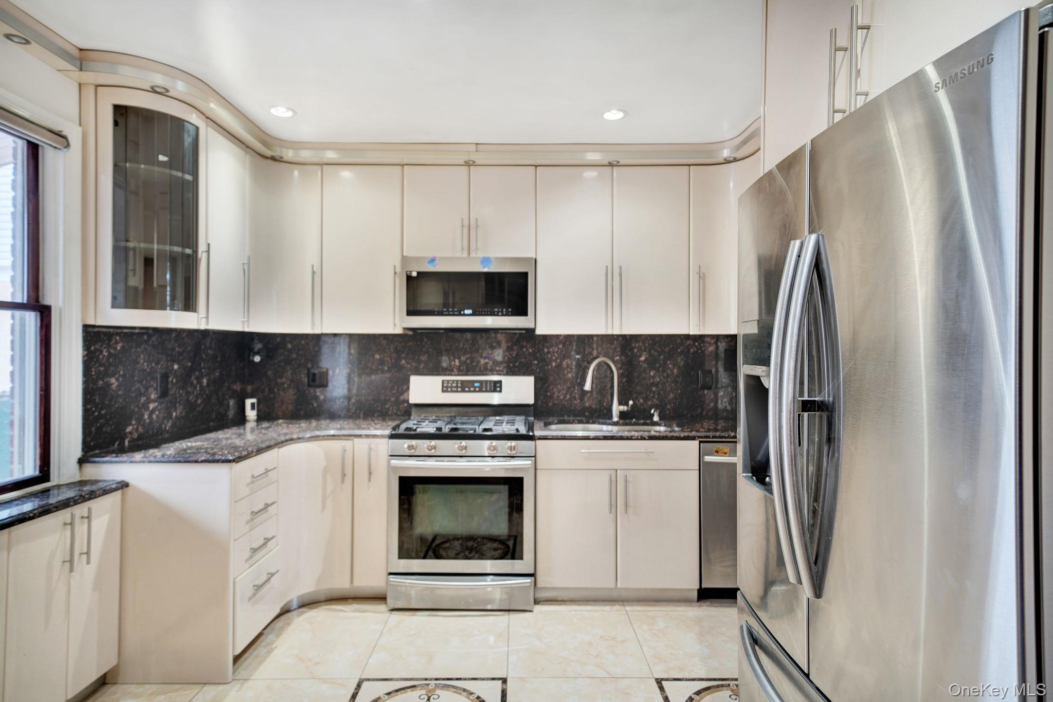 87-67 Chevy Chase Street Queens, NY 11432 - Photo 11 of 31 a kitchen with stainless steel appliances granite countertop a refrigerator sink and stove