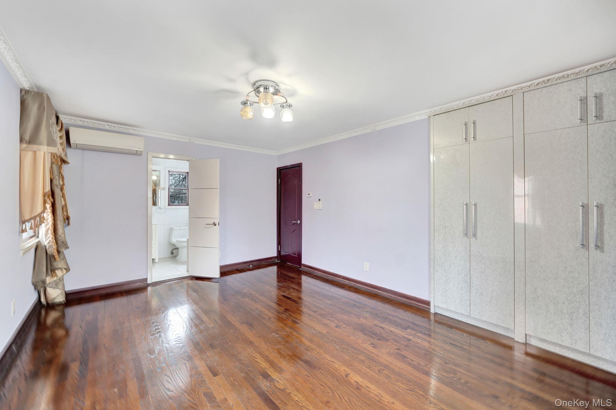 87-67 Chevy Chase Street Queens, NY 11432 - Photo 19 of 31 a view of an empty room with wooden floor and a window