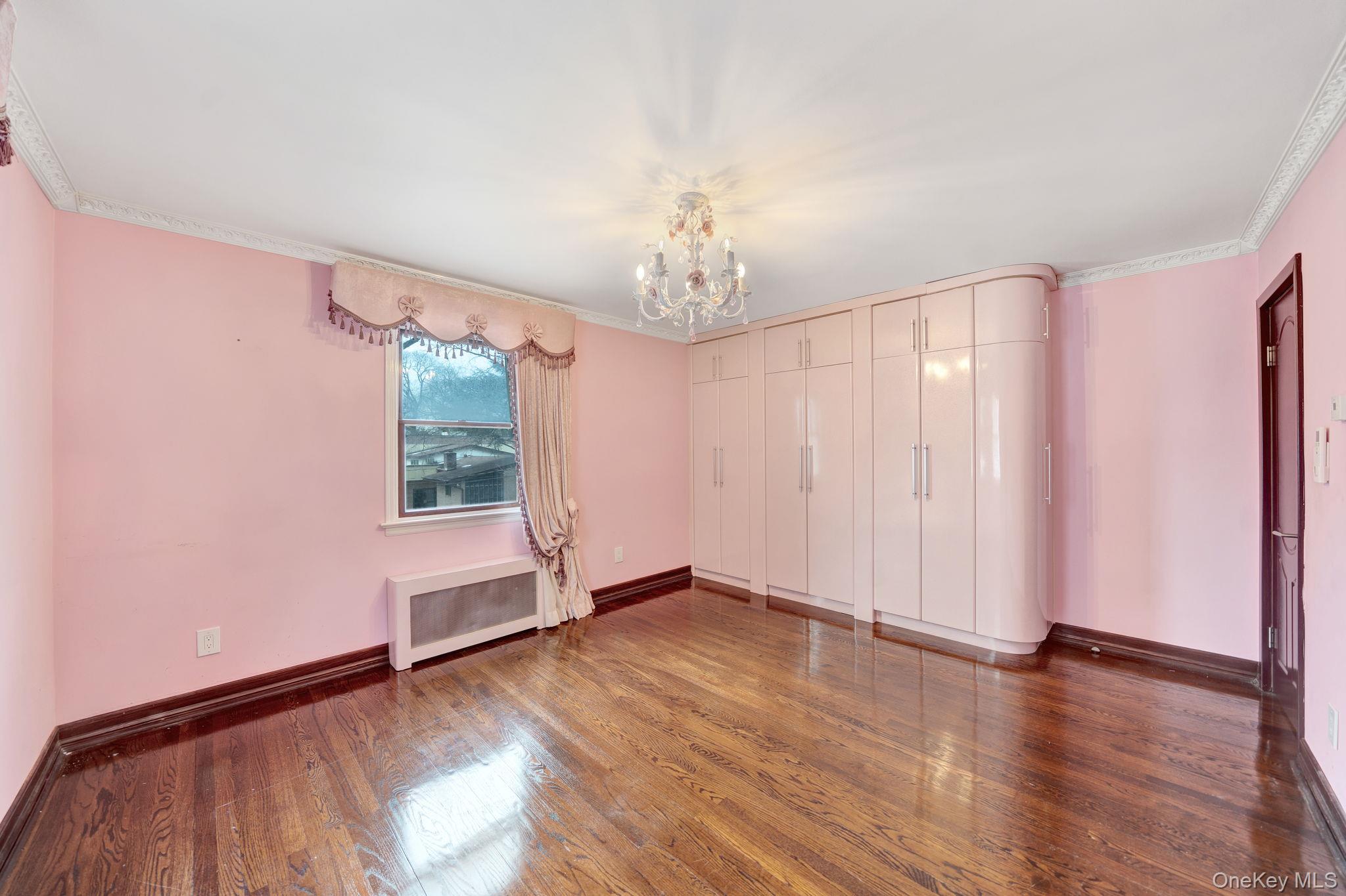 87-67 Chevy Chase Street Queens, NY 11432 - Photo 21 of 31 an empty room with wooden floor and windows