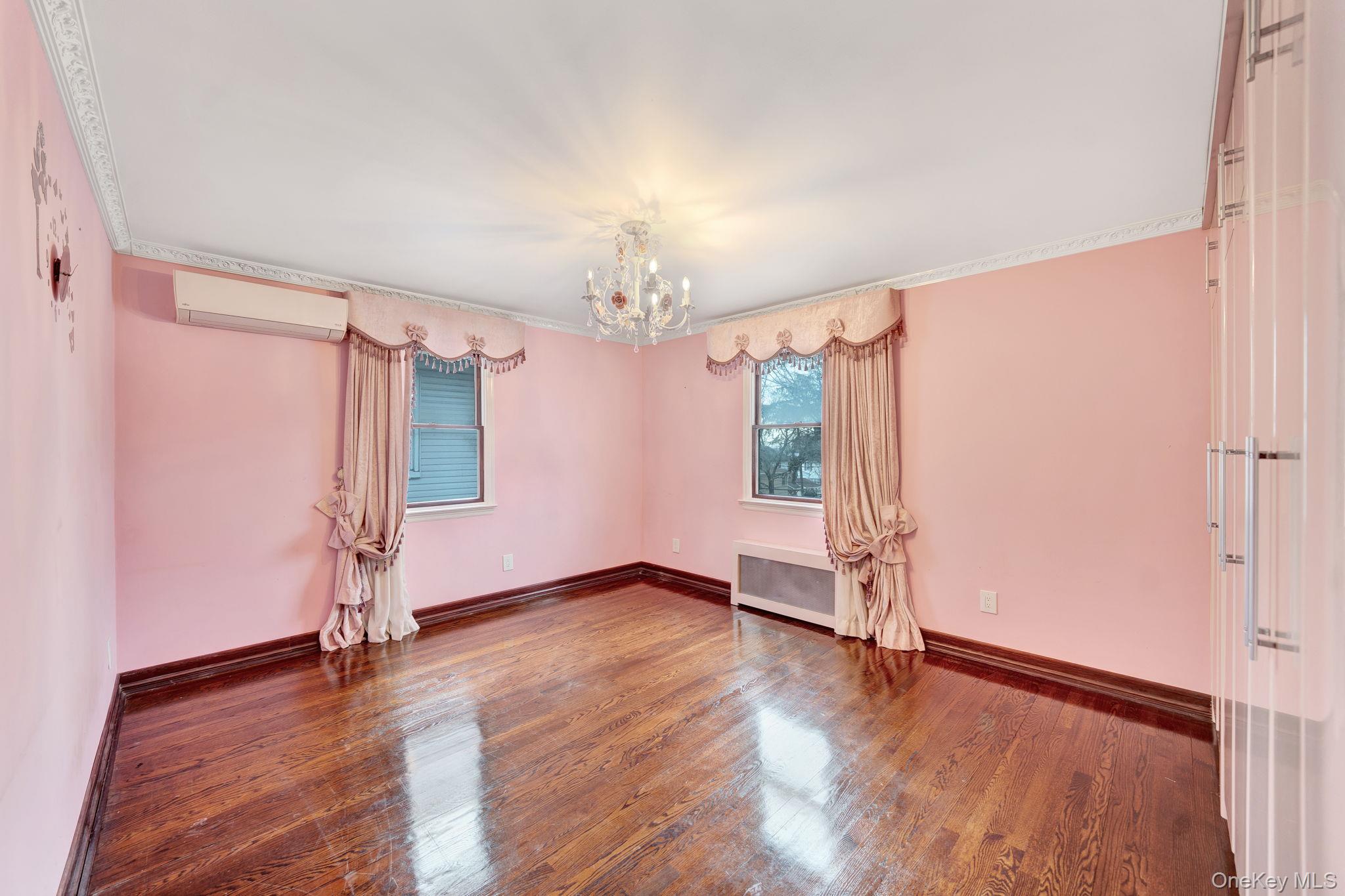87-67 Chevy Chase Street Queens, NY 11432 - Photo 22 of 31 an empty room with wooden floor and window