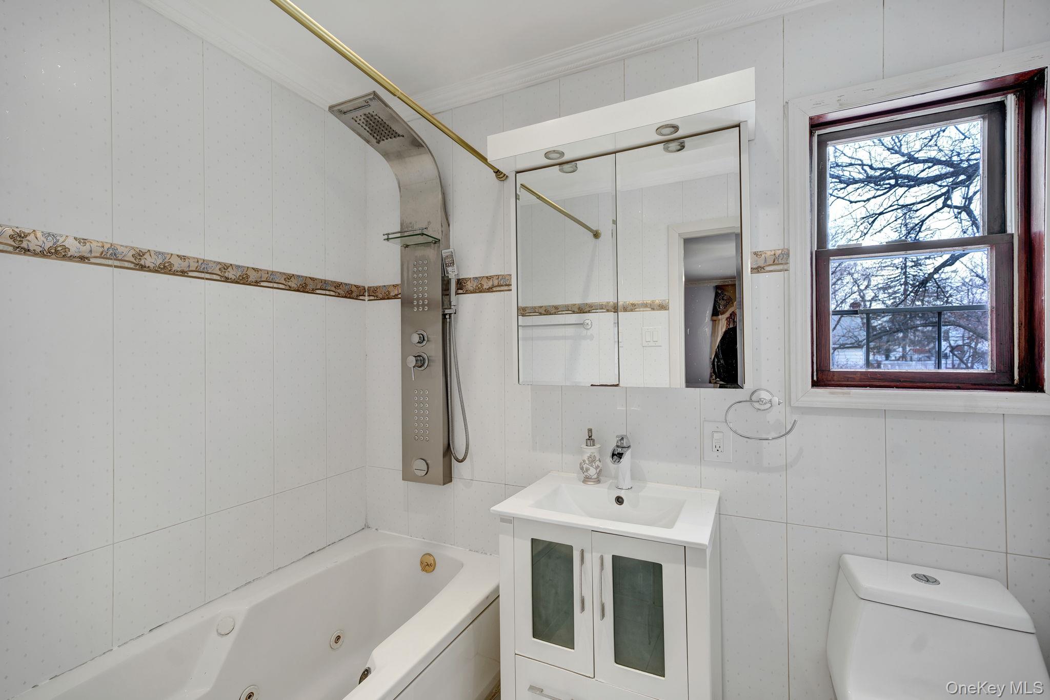 87-67 Chevy Chase Street Queens, NY 11432 - Photo 25 of 31 a bathroom with a sink a mirror and a bathtub