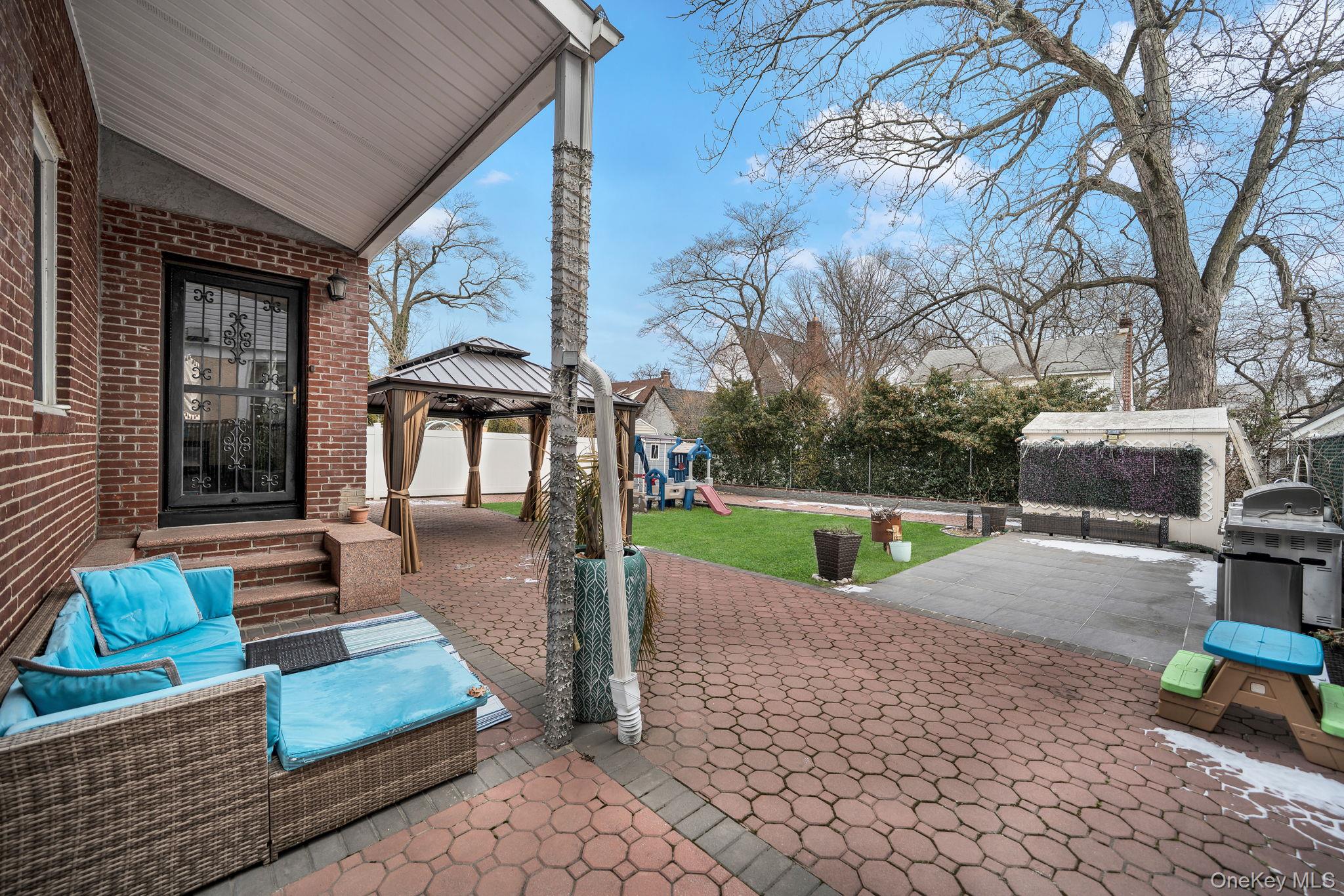87-67 Chevy Chase Street Queens, NY 11432 - Photo 31 of 31 a view of a patio with a table chairs and a yard