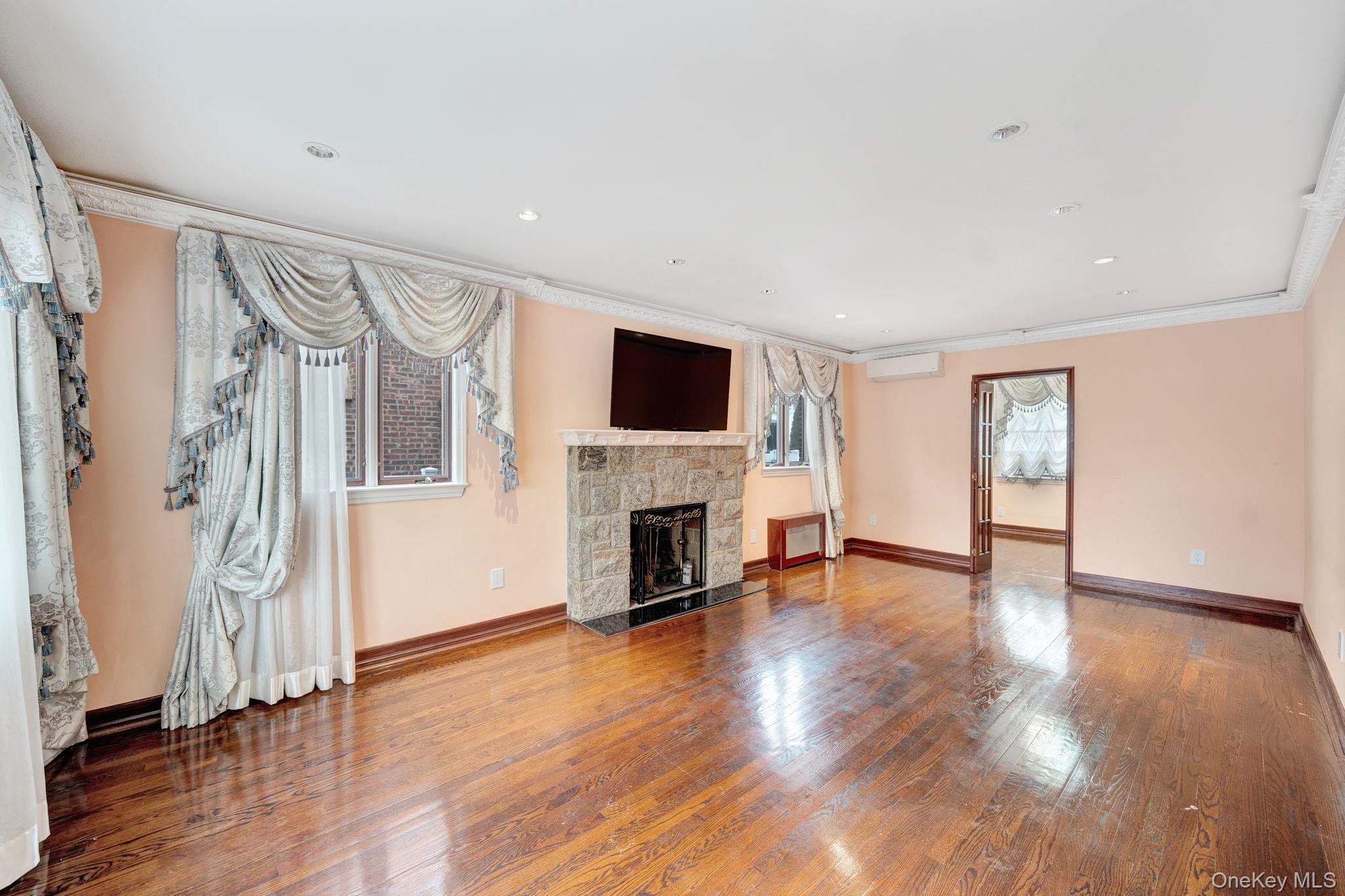 87-67 Chevy Chase Street Queens, NY 11432 - Photo 8 of 31 a view of a livingroom with wooden floor and a fireplace