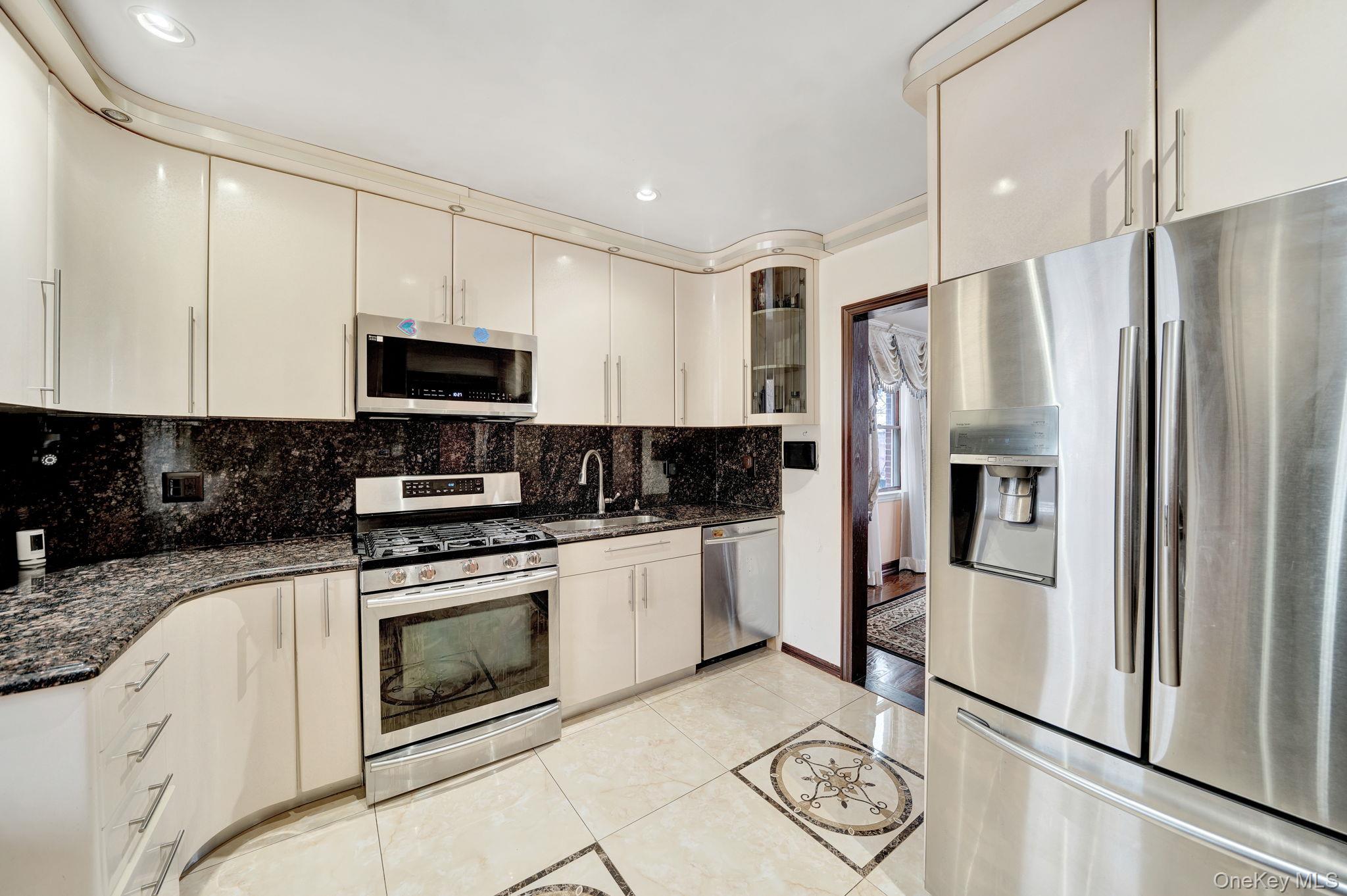 87-67 Chevy Chase Street Queens, NY 11432 - Photo 10 of 31 a kitchen with stainless steel appliances granite countertop a refrigerator a stove a sink and a granite counter tops