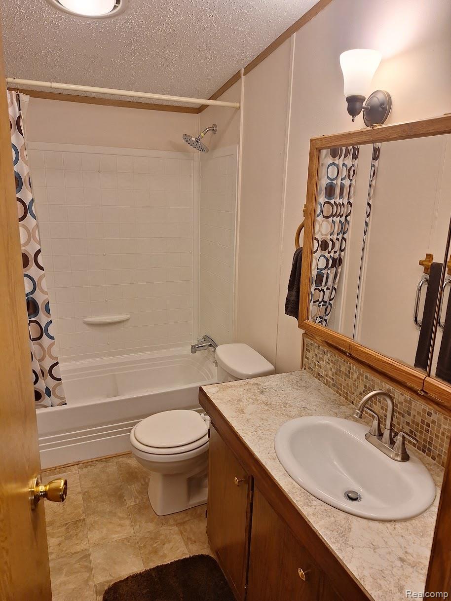 2500-mann Rd Mann Road Clarkston, MI 48346 - Photo 8 of 22 Bathroom featuring a vanity with an integrated sink, laminate countertop, and mosaic tile backsplash