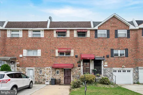 a front view of a building with a garden and plants