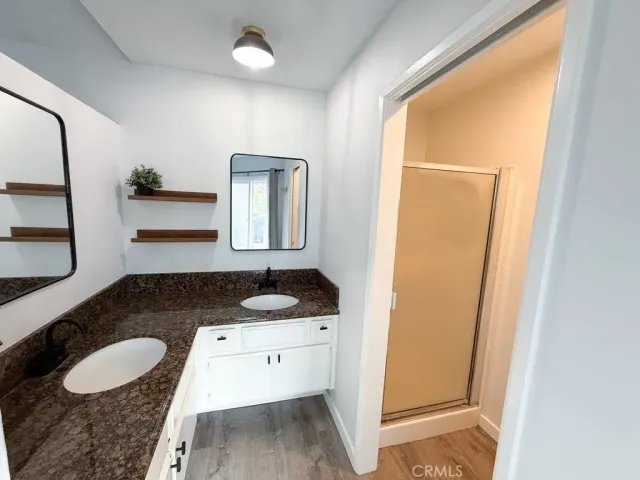 a en suite bathroom with a granite countertop sink and a mirror