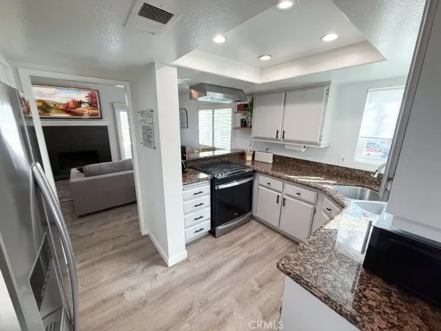 a kitchen with stainless steel appliances granite countertop a stove a sink and a refrigerator