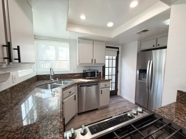 a kitchen with stainless steel appliances granite countertop a stove a refrigerator and a sink