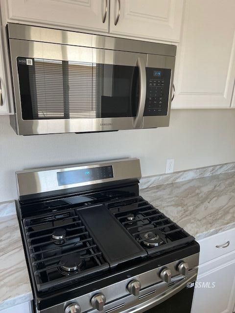 436 North Warner Street Ridgecrest, CA 93555 - Photo 10 of 30 a close view of a stove a microwave and cabinets