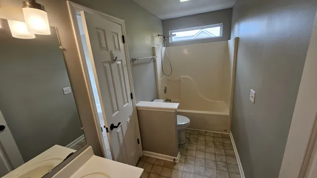 a bathroom with a sink a toilet a mirror and shower