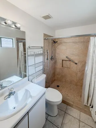 a bathroom with a sink a toilet and shower