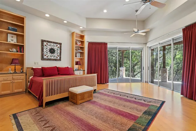 a view of a bedroom with natural light and hardwood floor