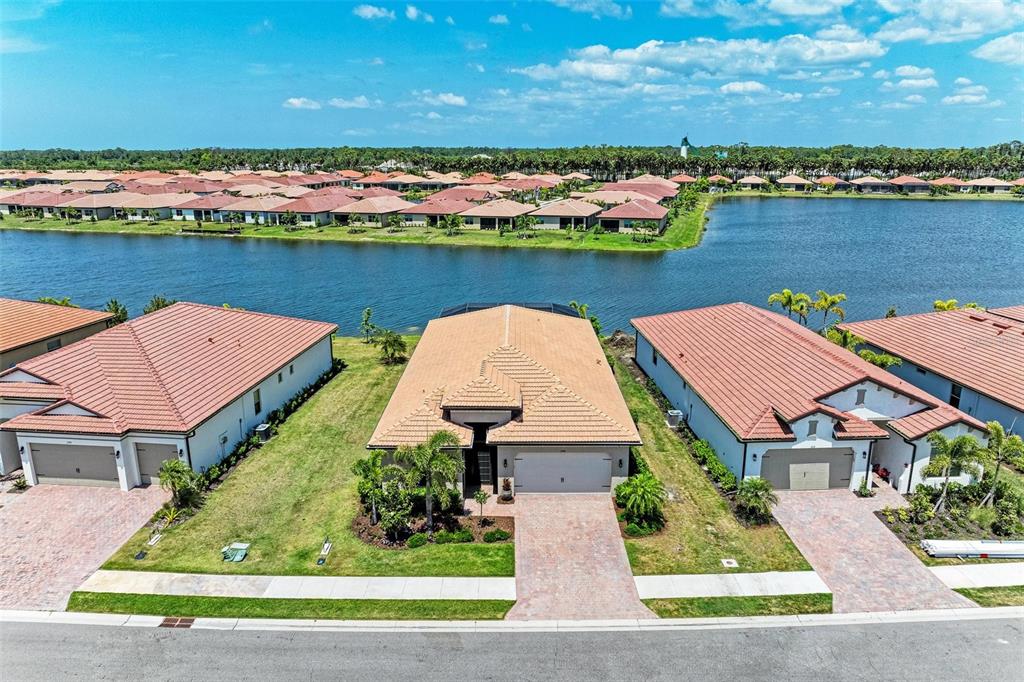 an aerial view of house with yard lake and ocean view