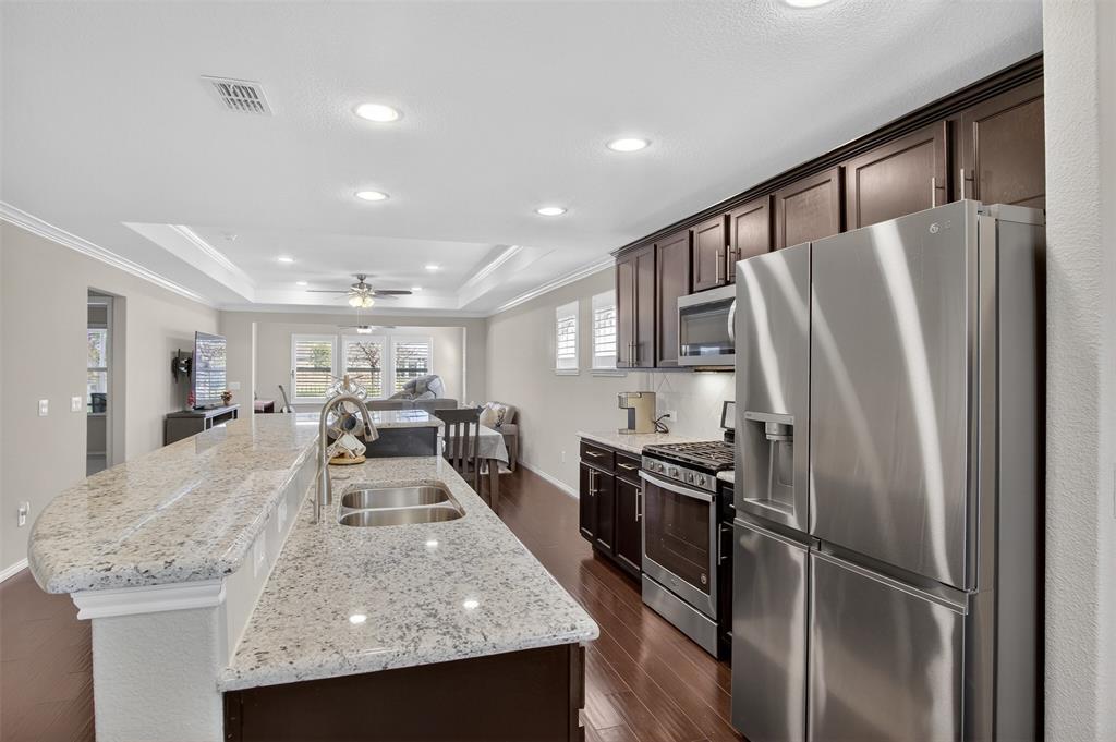 8978 Shore Crest Road Frisco, TX 75036 - Photo 7 of 40 a kitchen with stainless steel appliances granite countertop a sink refrigerator and cabinets