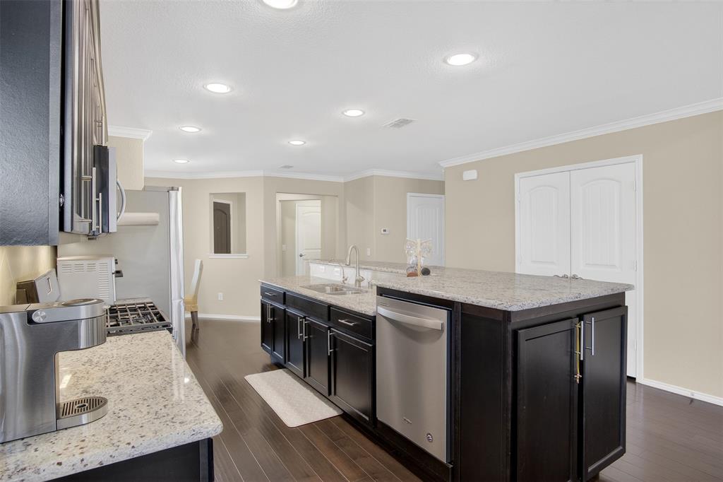 8978 Shore Crest Road Frisco, TX 75036 - Photo 8 of 40 a kitchen with a stove a sink dishwasher and a refrigerator with wooden floor