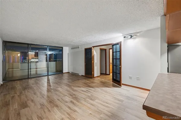 a view of a kitchen with wooden floor and electronic appliances
