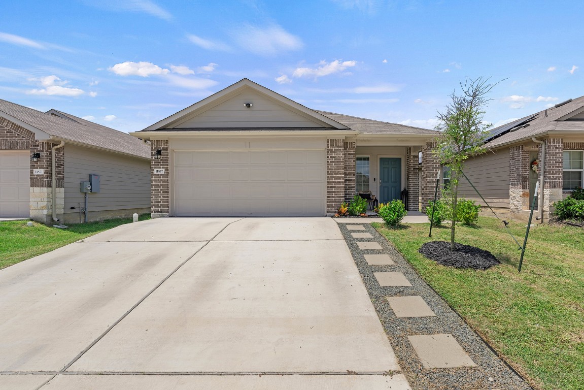 11817 Rush Lane Elgin, TX 78621 - Photo 2 of 30 a front view of a house with a yard and potted plants