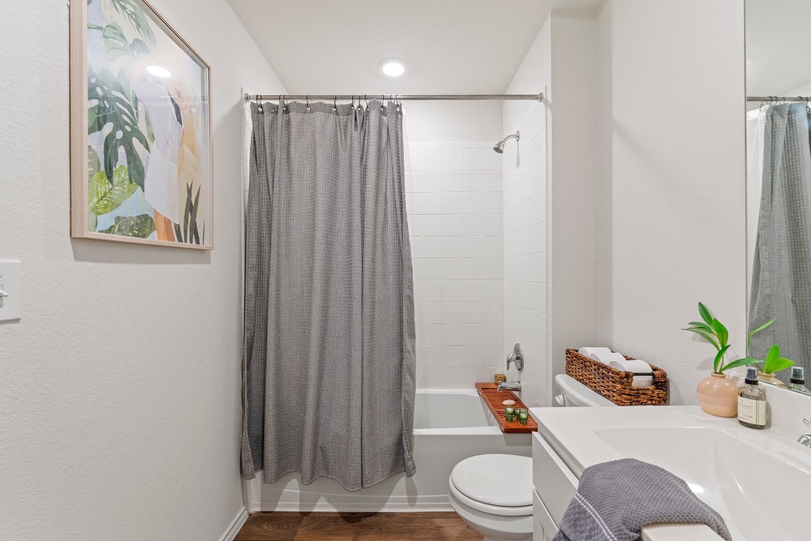 11817 Rush Lane Elgin, TX 78621 - Photo 24 of 30 a bathroom with a sink a toilet and shower curtain