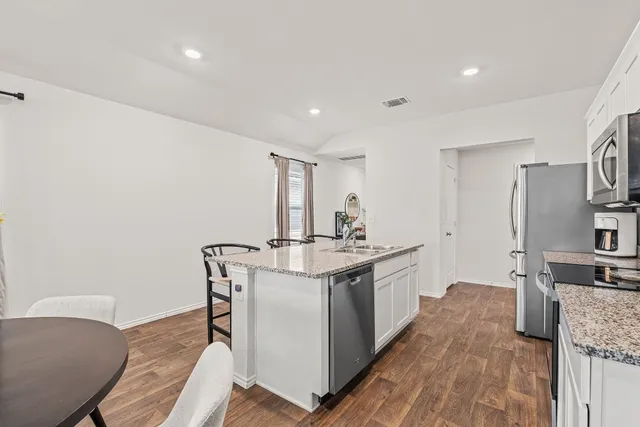 a kitchen with sink stove microwave and refrigerator